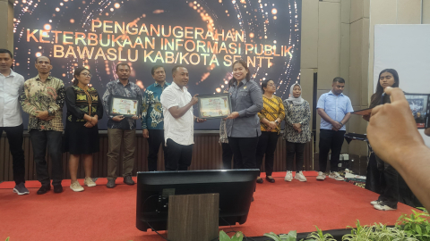 Anggota Bawaslu NTT menyerahkan Penghargaan Keterbukaan Informasi Publik